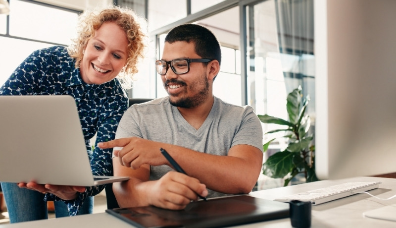 Teamarbeit: Zwei Personen arbeiten am Laptop